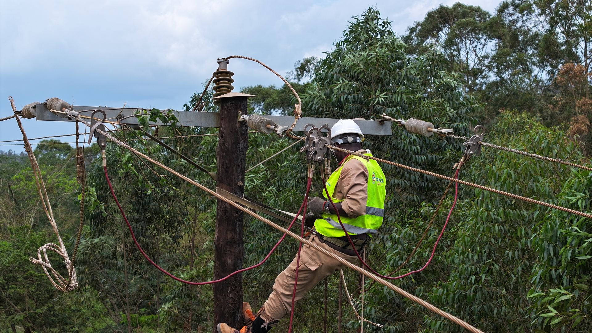 Lineworker in protective gear working on an overhead line